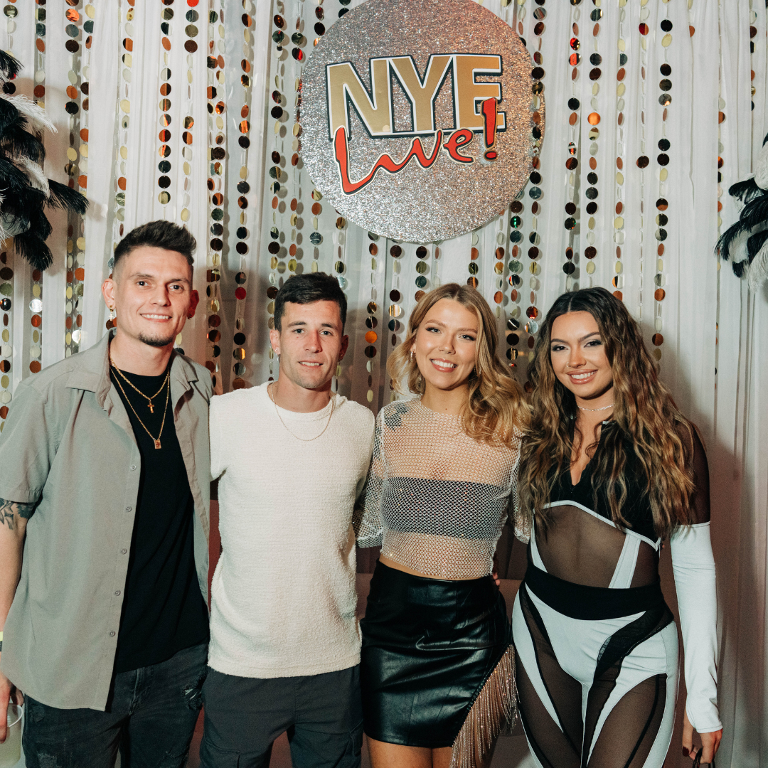Group of friends posing in front of New Year's Eve photo op at Ballpark Village NYE party