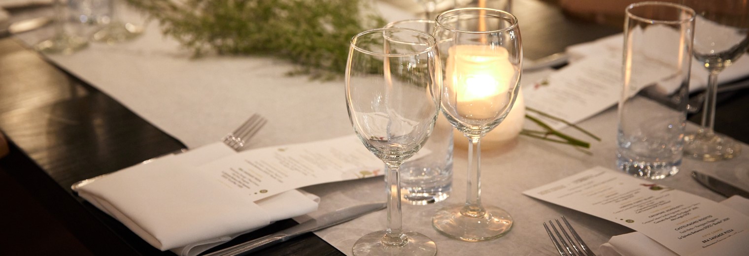 Table setting with utensils, linens, menus, glassware, and candles at Katie's Pizza & Pasta Osteria.
